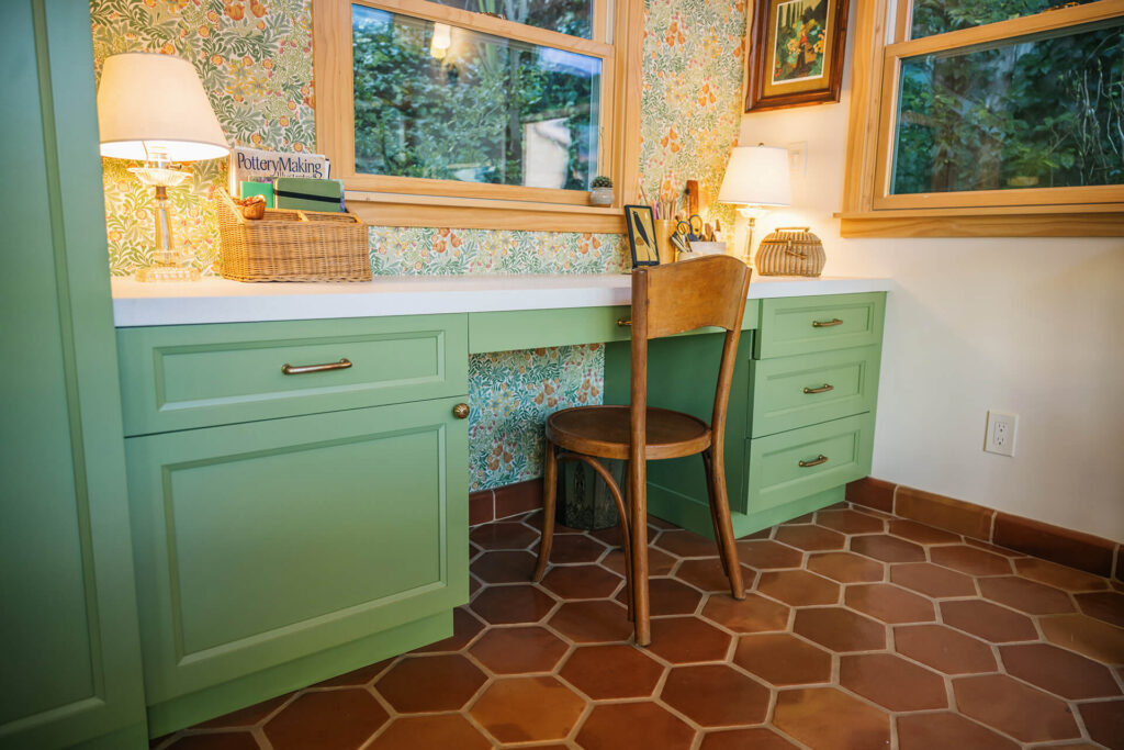 Cozy shed workspace with green cabinets and patterned wallpaper