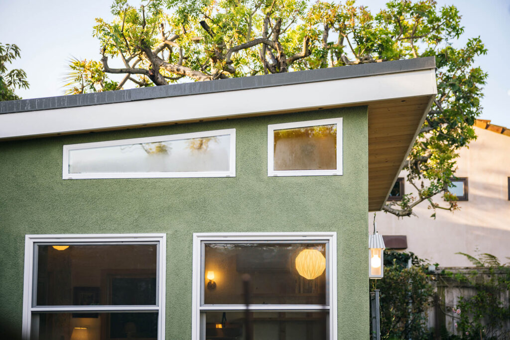 Green shed exterior with horizontal windows and flat roof