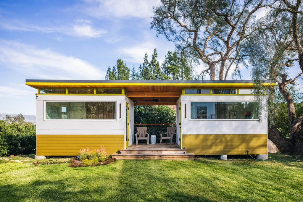 Modern prefab shed with covered patio and lawn