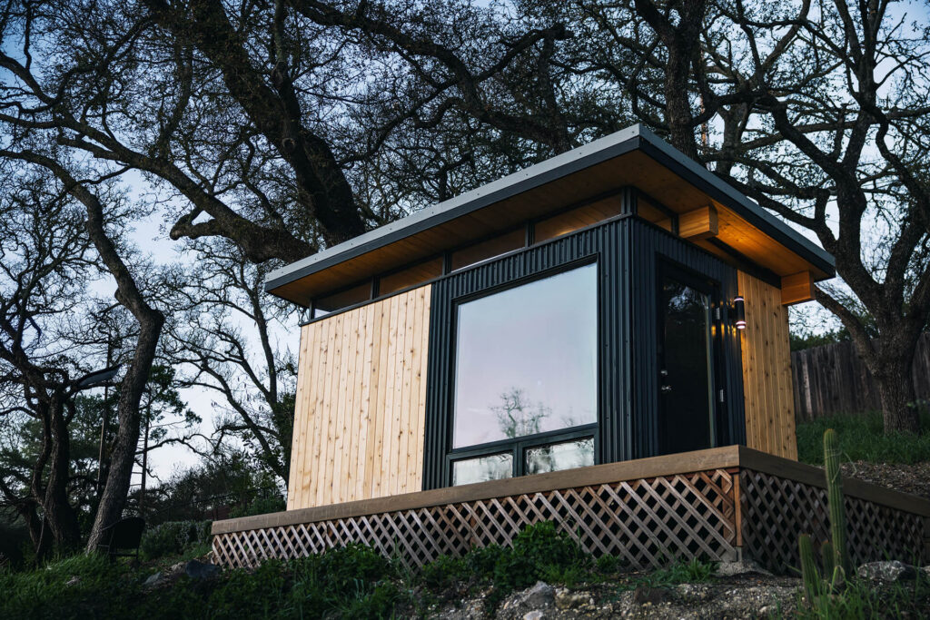 Compact shed cabin with wood and black exterior panels