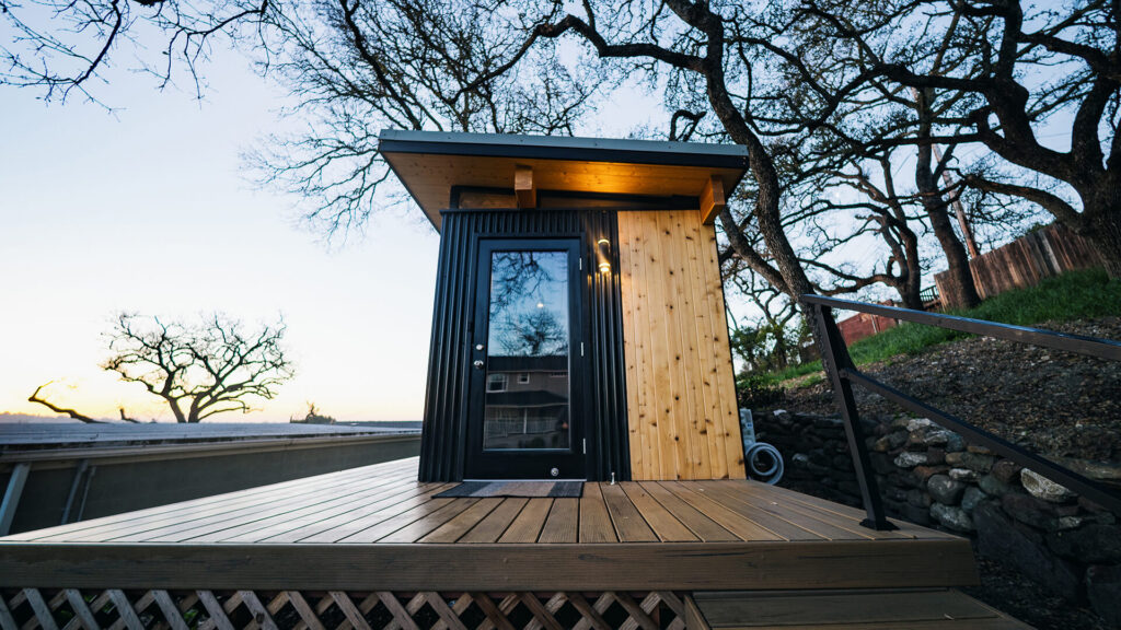 Small modern shed on deck with glass door at sunset