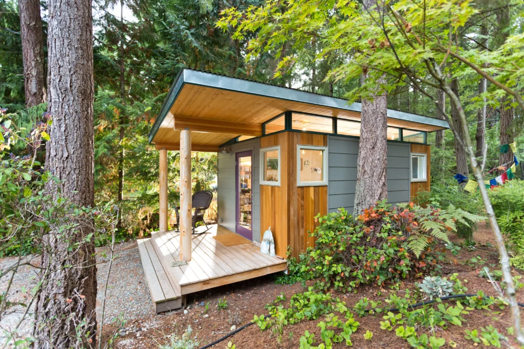 Contemporary garden shed with covered porch in wooded setting