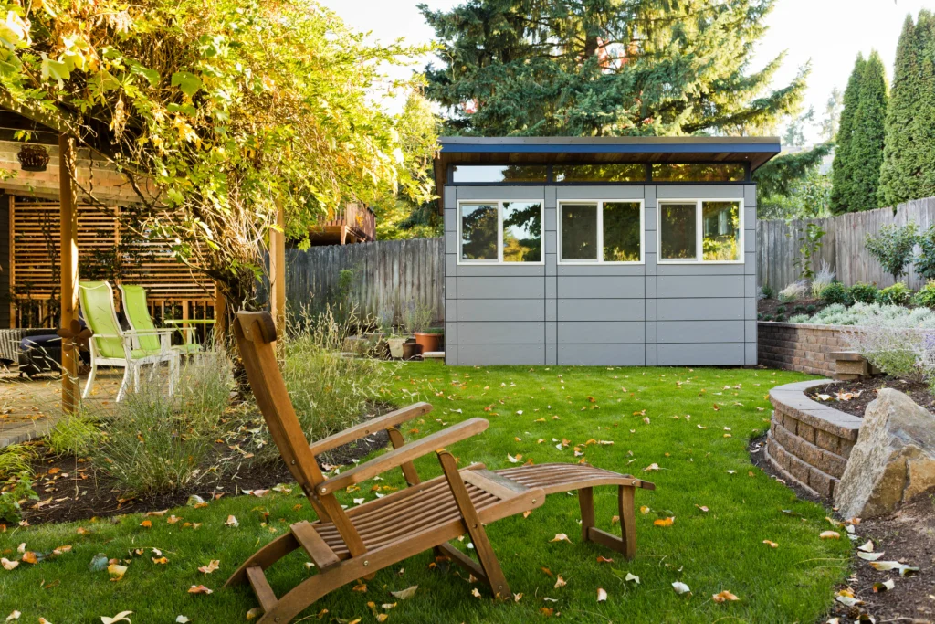 Minimalist gray backyard shed with landscaped lawn and seating