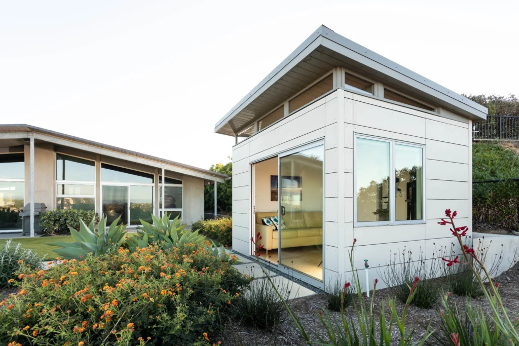 Minimalist white backyard studio with surrounding landscaping
